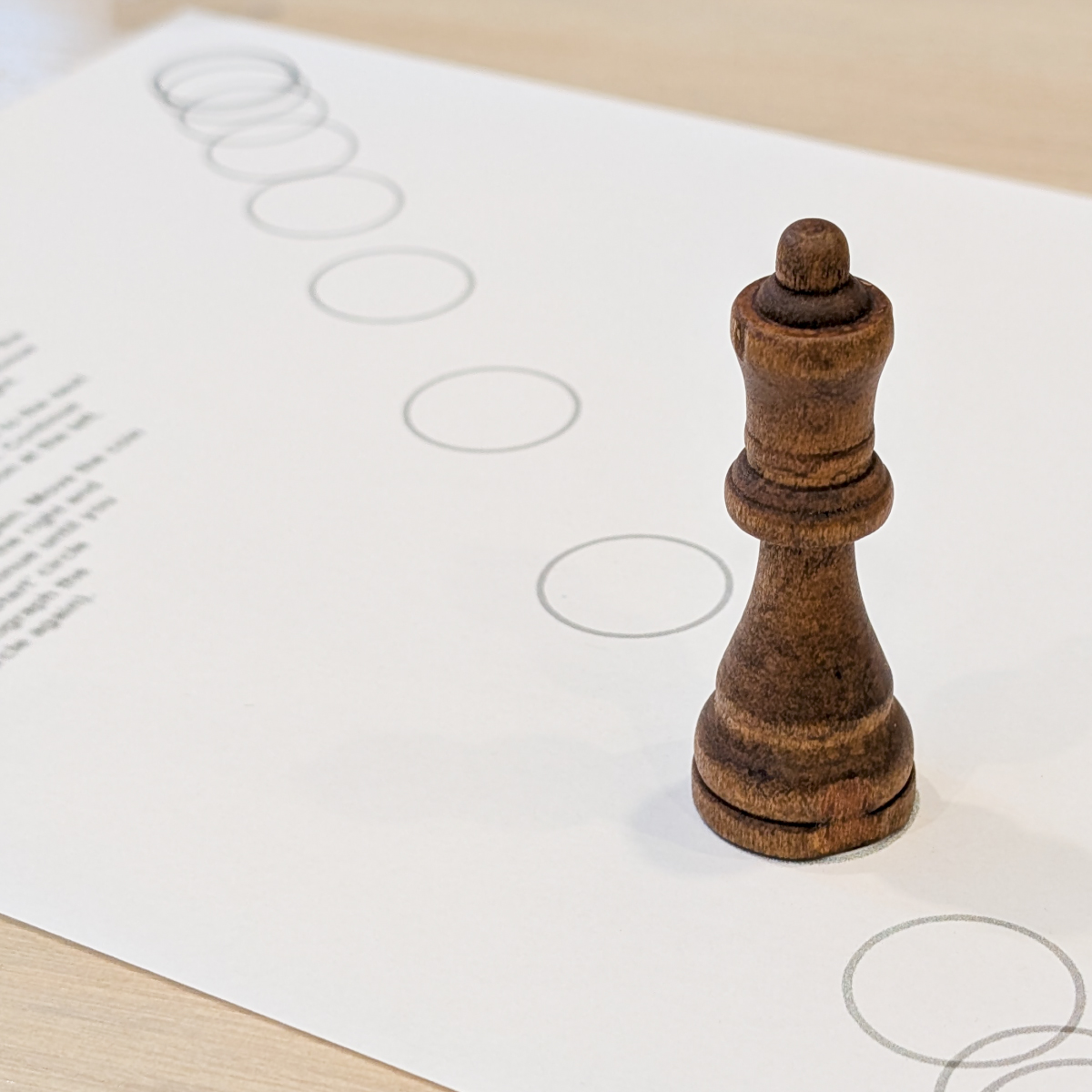 A wooden chess piece standing on the printed dot template